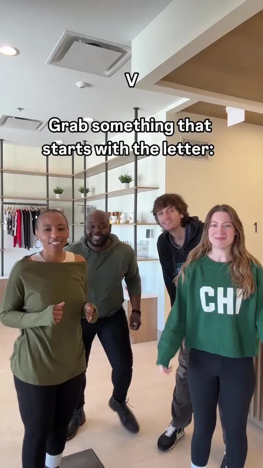 Four people in an office, captioned Grab something that starts with the letter