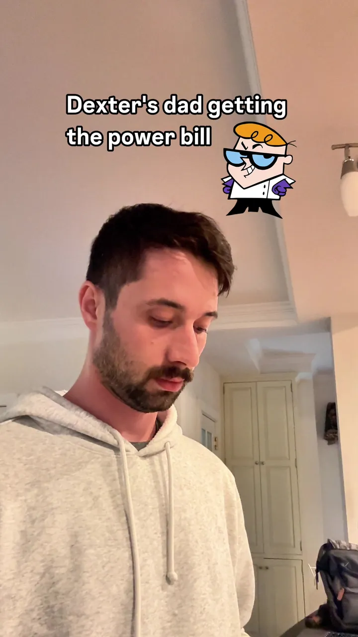 Morgan reading a bill at home, captioned Dexter's dad getting the power bill