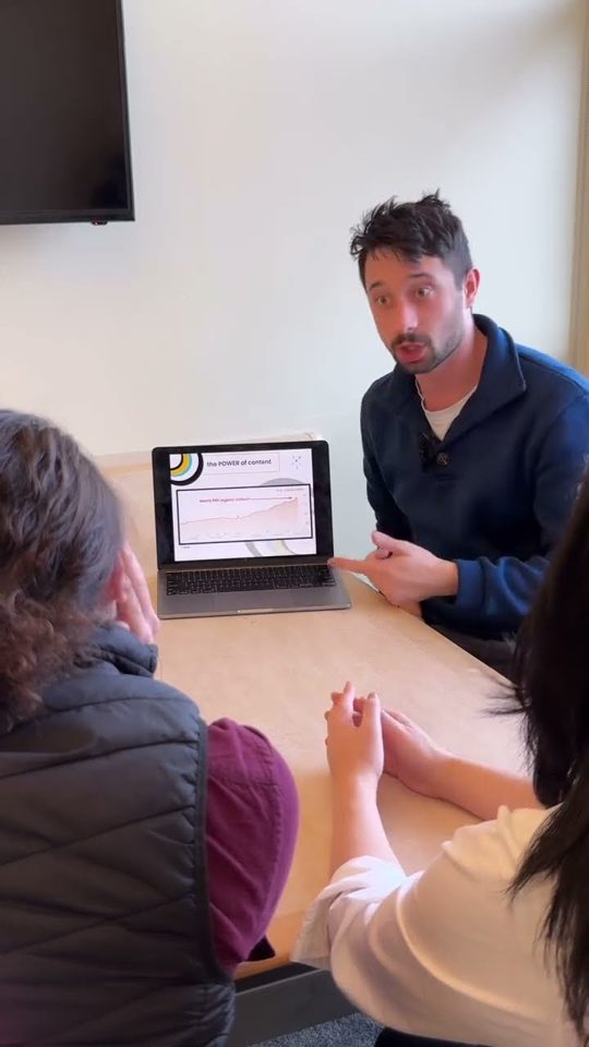 Morgan presenting from a laptop at a conference table
