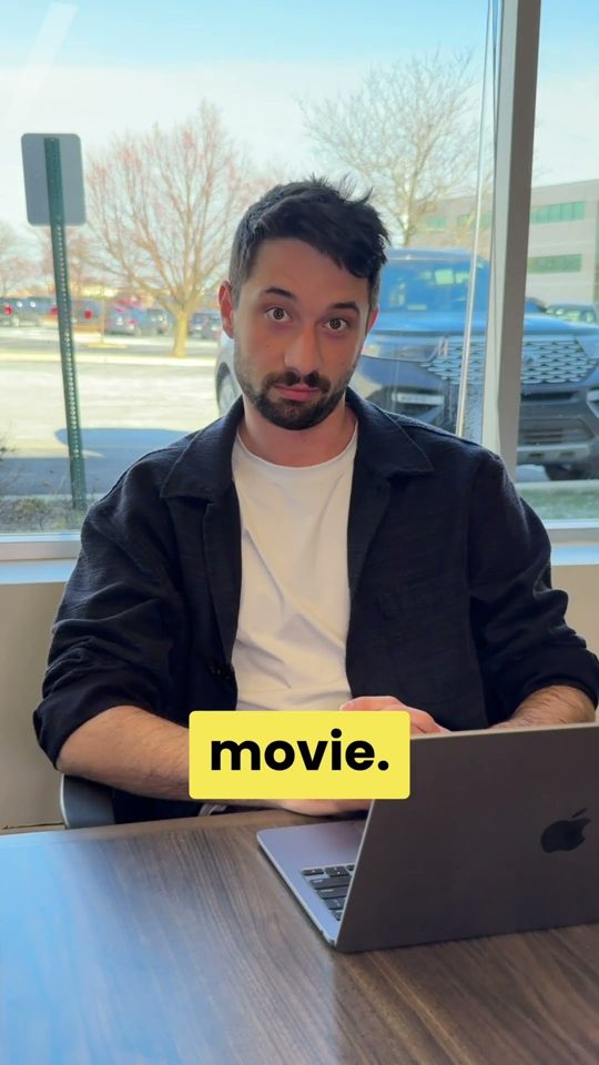Morgan at a laptop by an office window, captioned movie