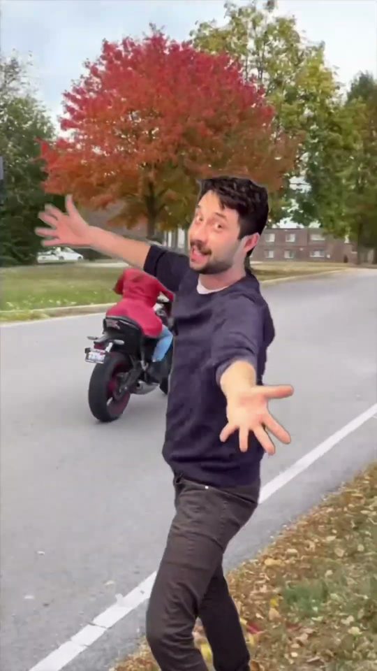Morgan with his arms spread wide on a tree-lined street, from his Short Hire me 2025