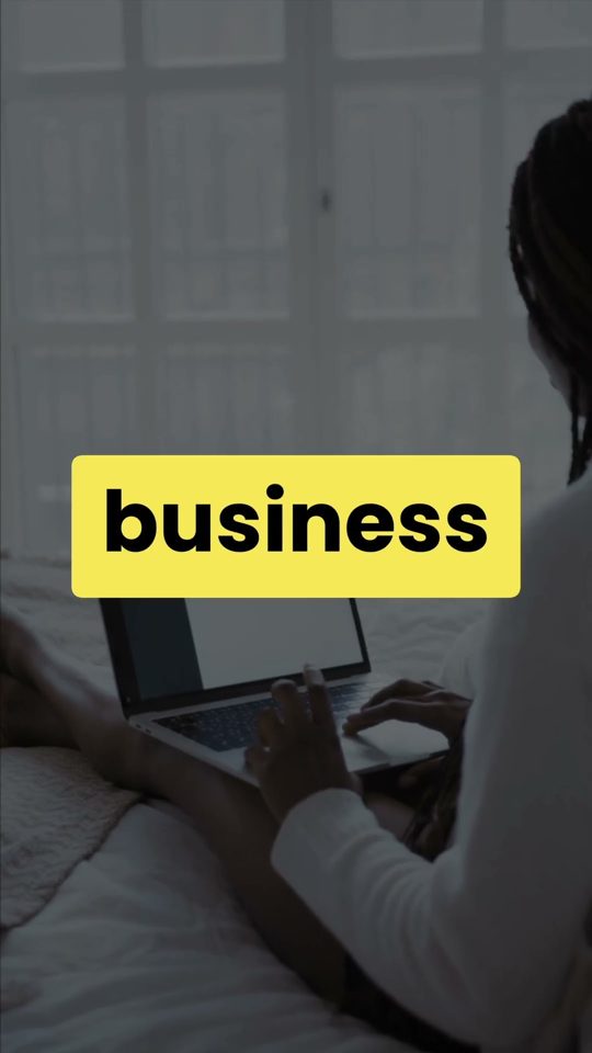 Someone typing on a laptop in bed, captioned business